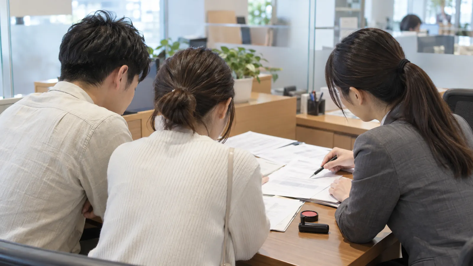 專員向年輕夫妻解說房貸文件,拉長年期讓還款更從容。
