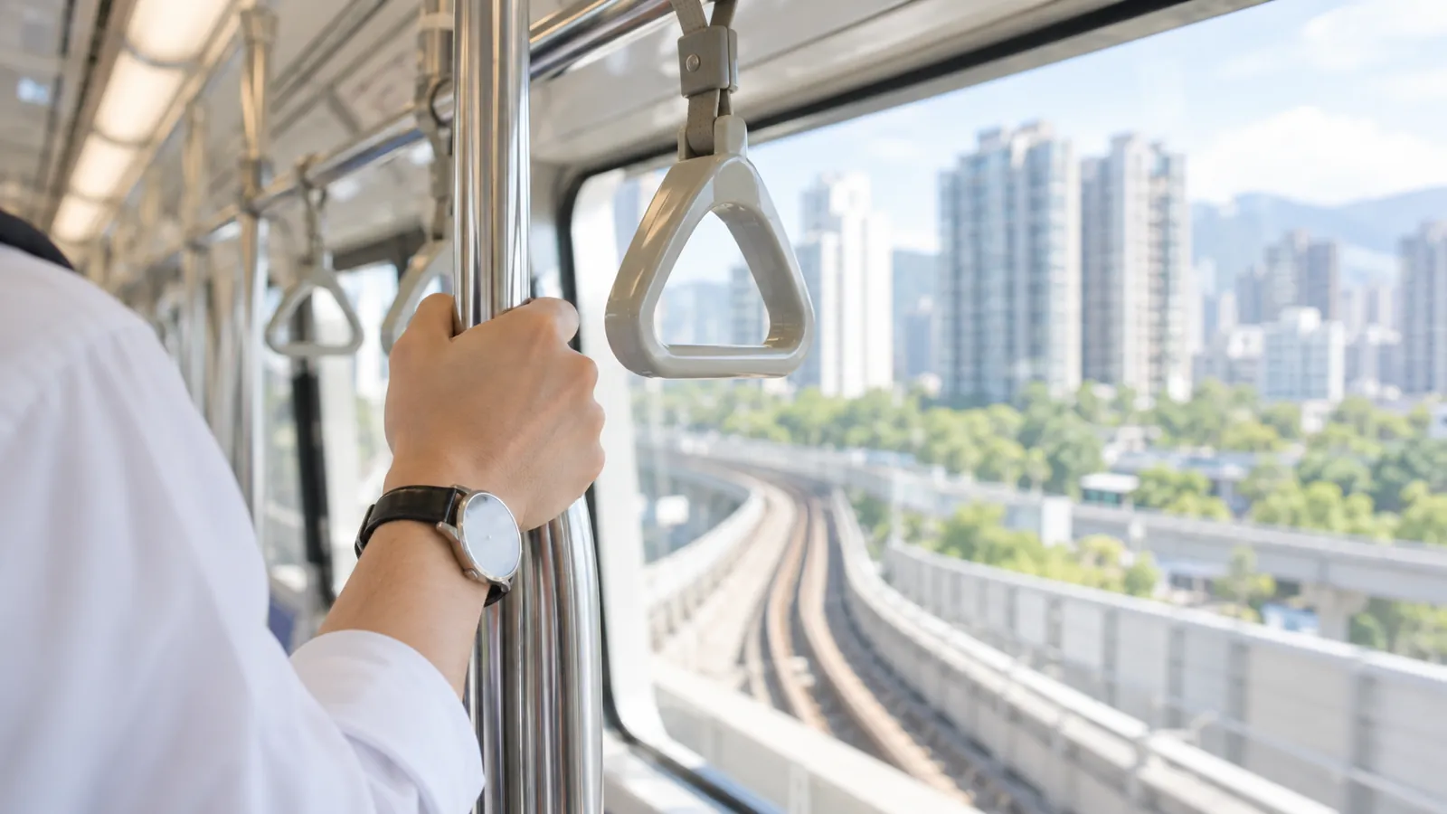 搭乘捷運沿著軌道前行，車窗外展開綠意與住宅街廓。