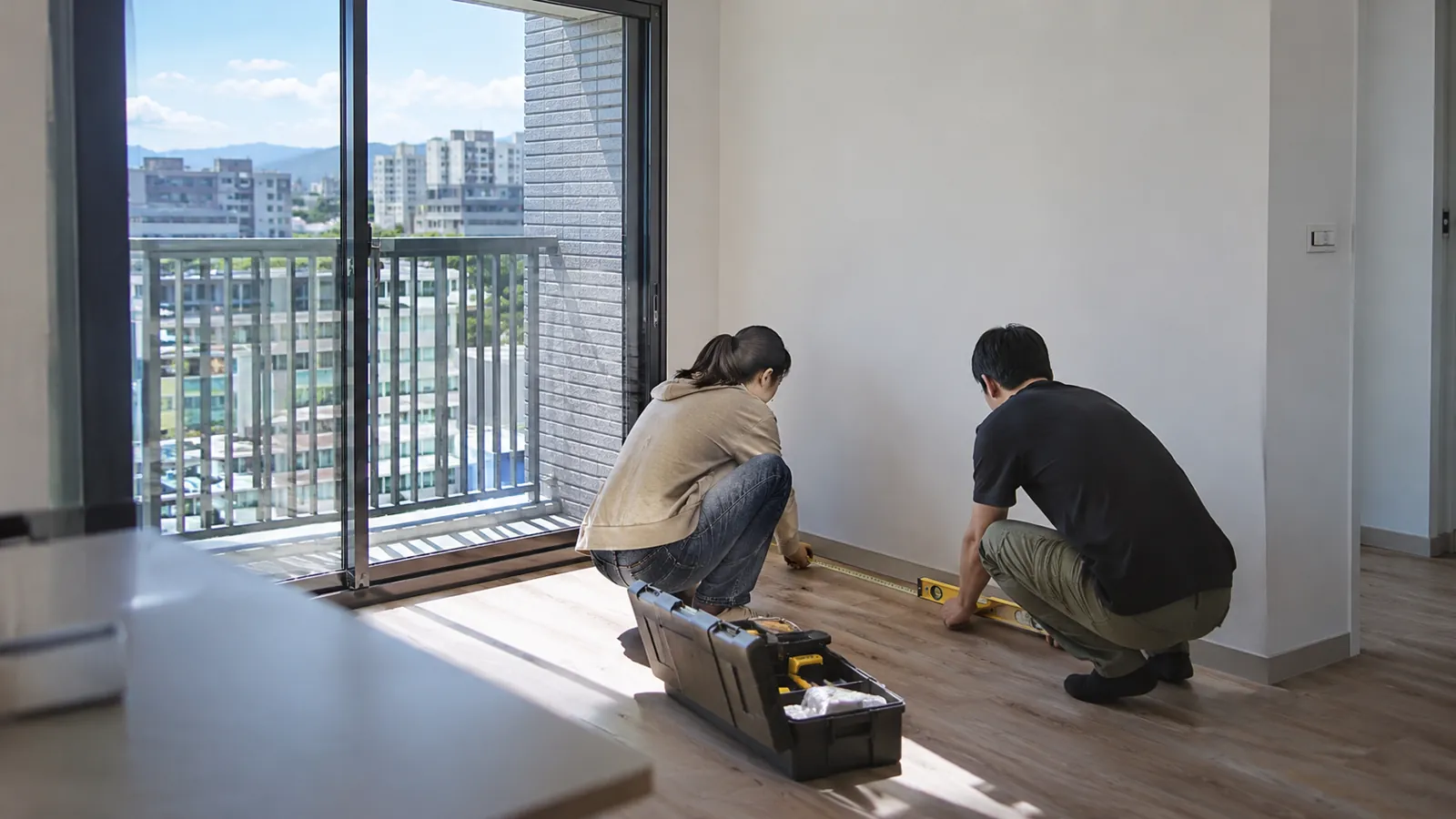 屋主手持量尺與水平儀,在明亮新居中仔細檢視施工細節。