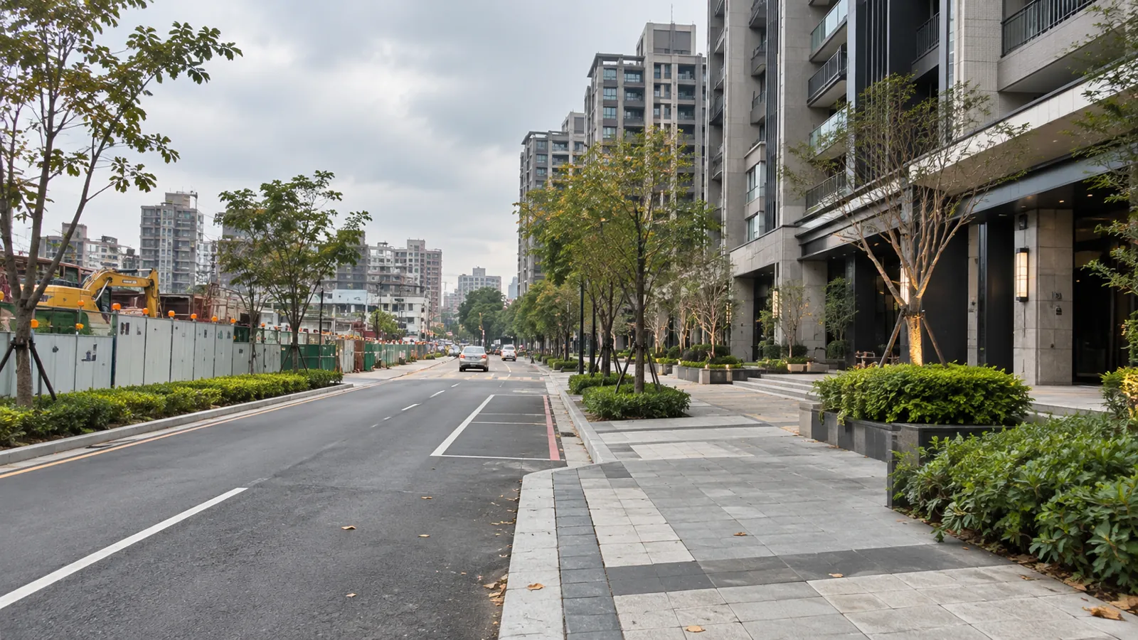 工程圍籬旁的平整道路，串連起新建大樓與綠意街廓。